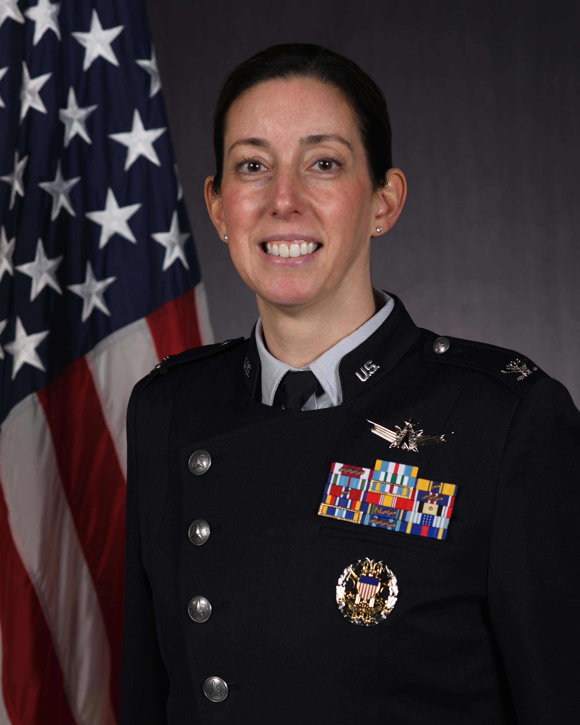Portrait photo of Delta 1 Commander Col. Krista N. St Romain with U.S. flag behind her