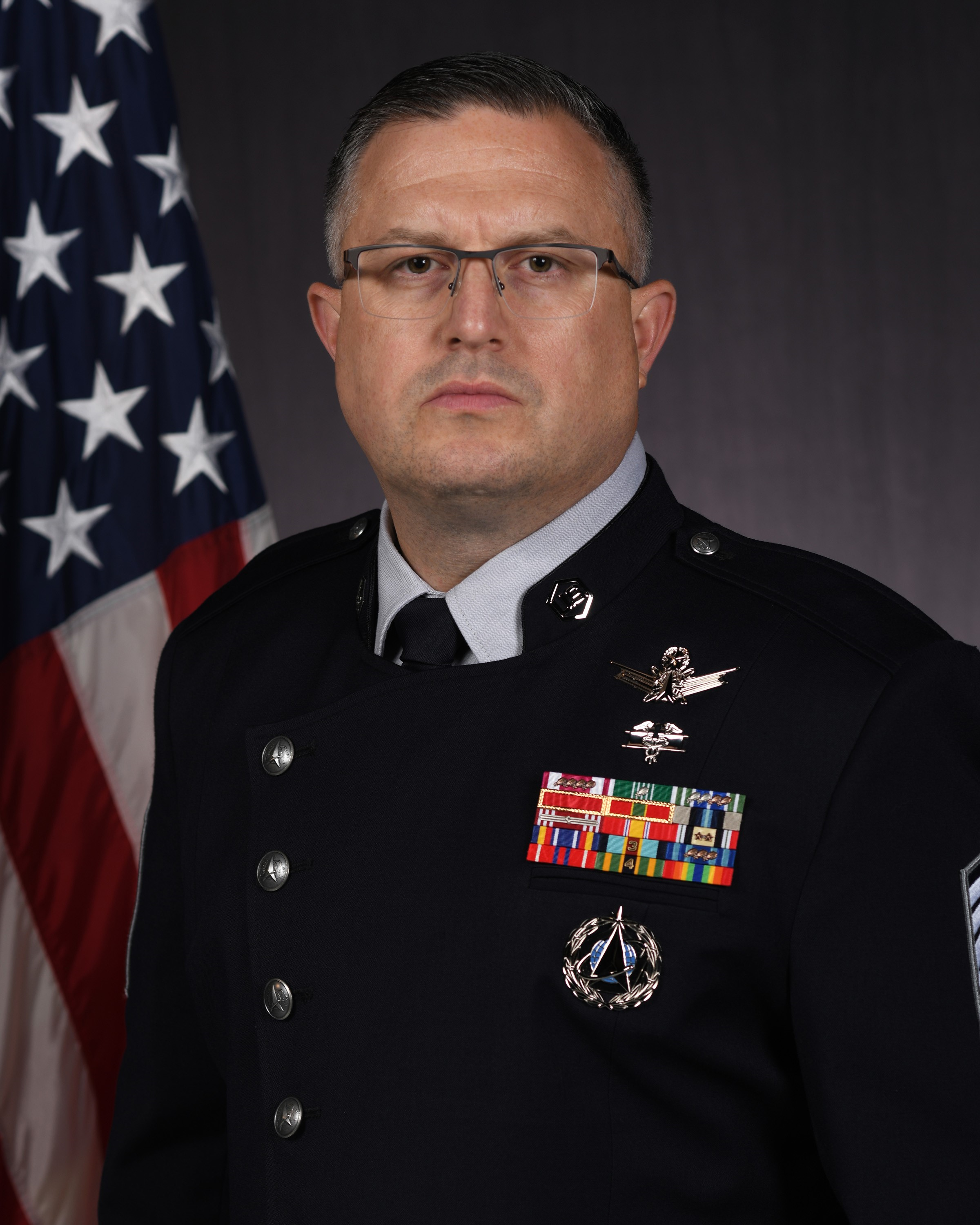 Official photo of CMSgt Ryan Dawson with U.S. flag and Space Force flag behind him