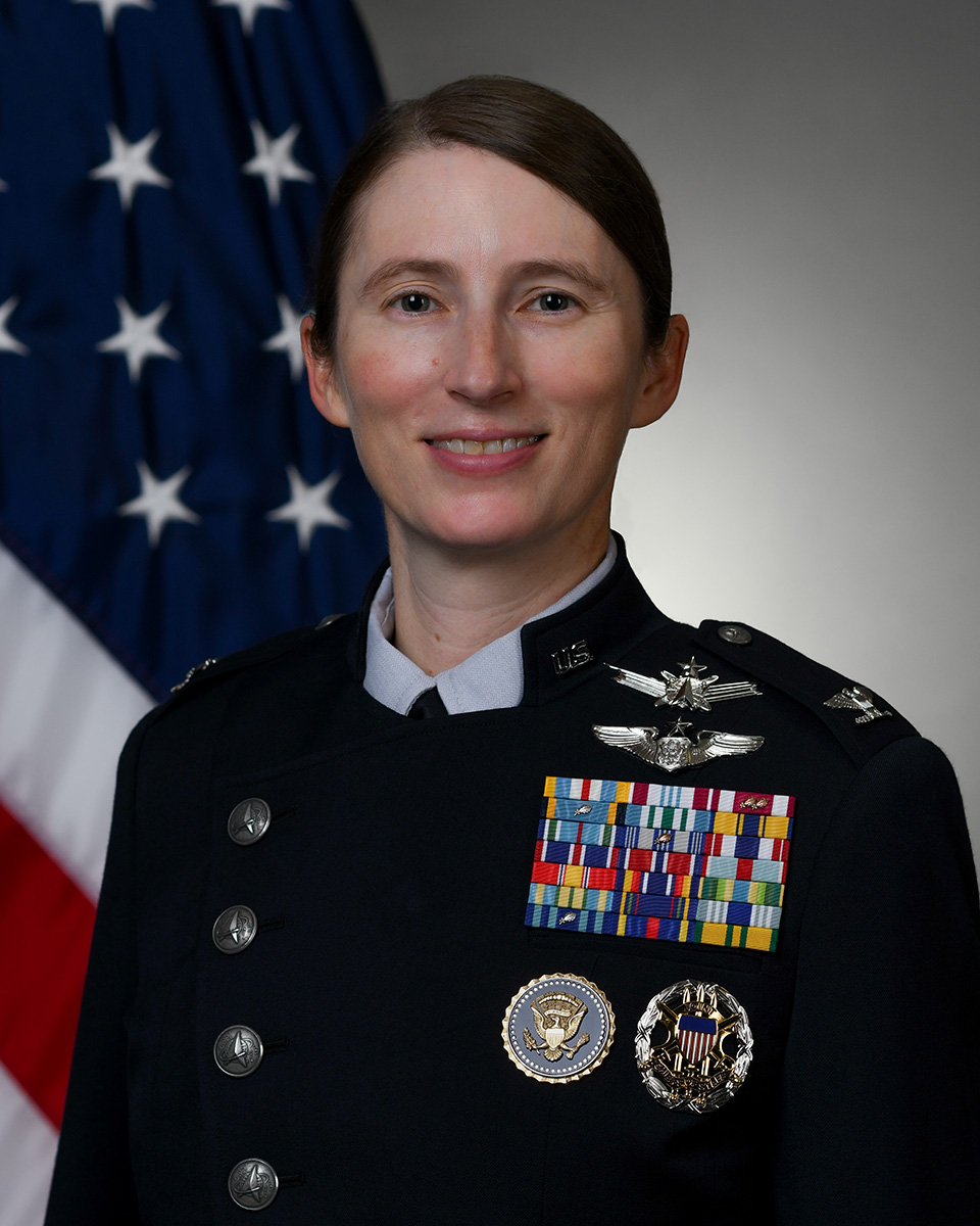Official photo of Col. Sacha Tomlinson with U.S. flag in background